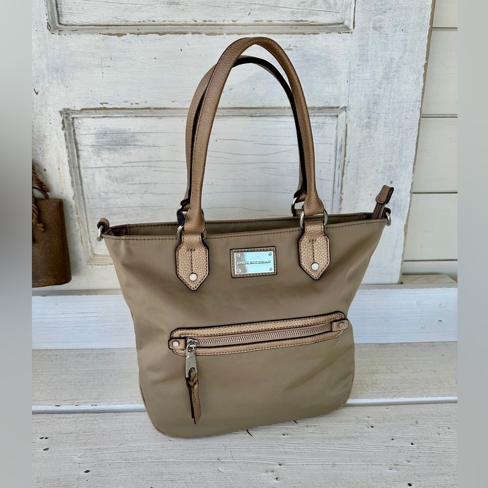 DANA BUCHMAN HANDBAG. 100% NYLON FABRIC WITH PEBBLED METALLIC HANDLE & TRIM.